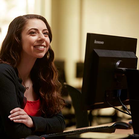 Female business student sitting in class at computer
